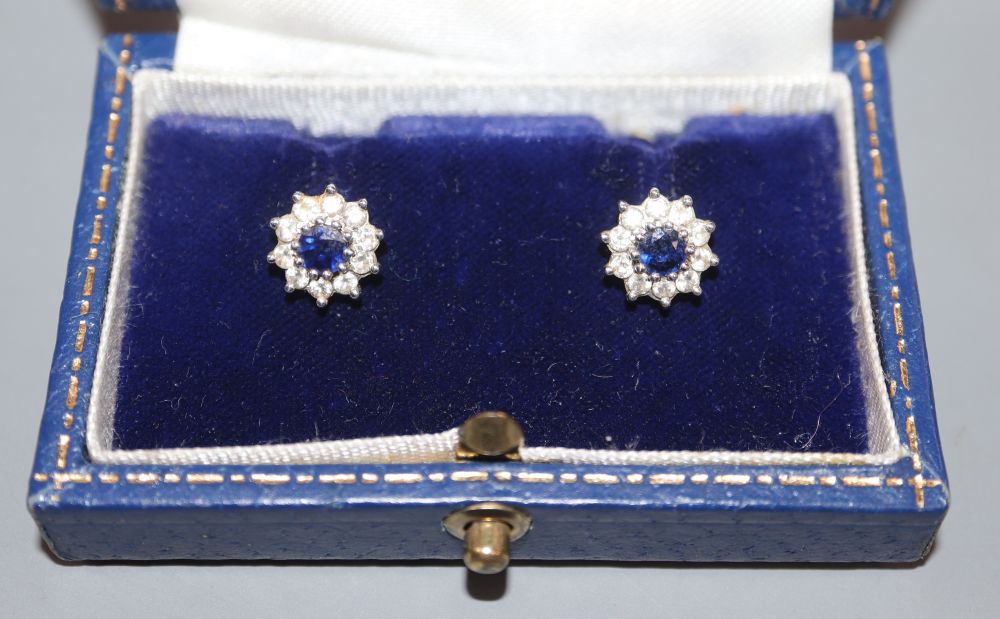 A modern pair of 18ct white gold, sapphire and diamond set circular cluster rings, 9mm, gross 3.2 grams.